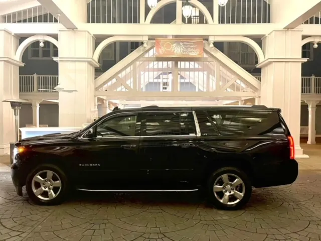 Black Suburban waiting at a resort entrance at night