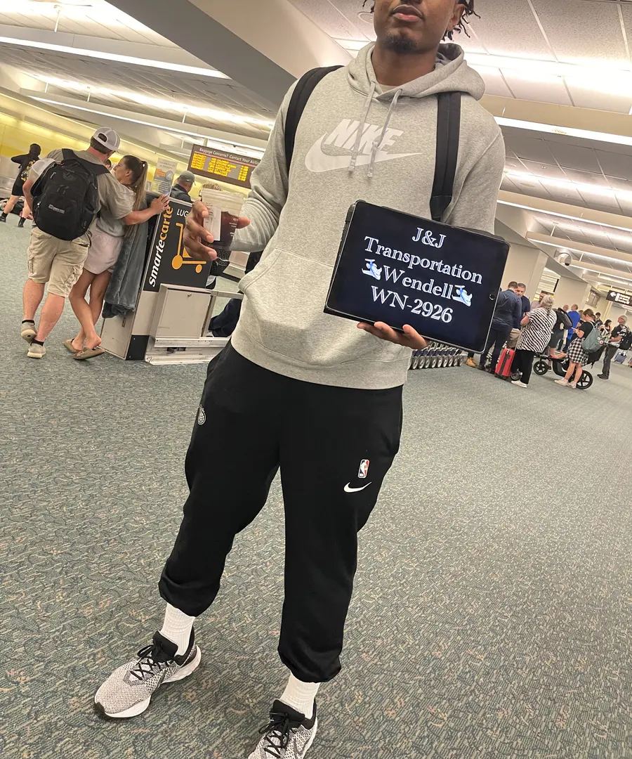 Guest welcomed at baggage claim with a personalized J&J Transportation sign